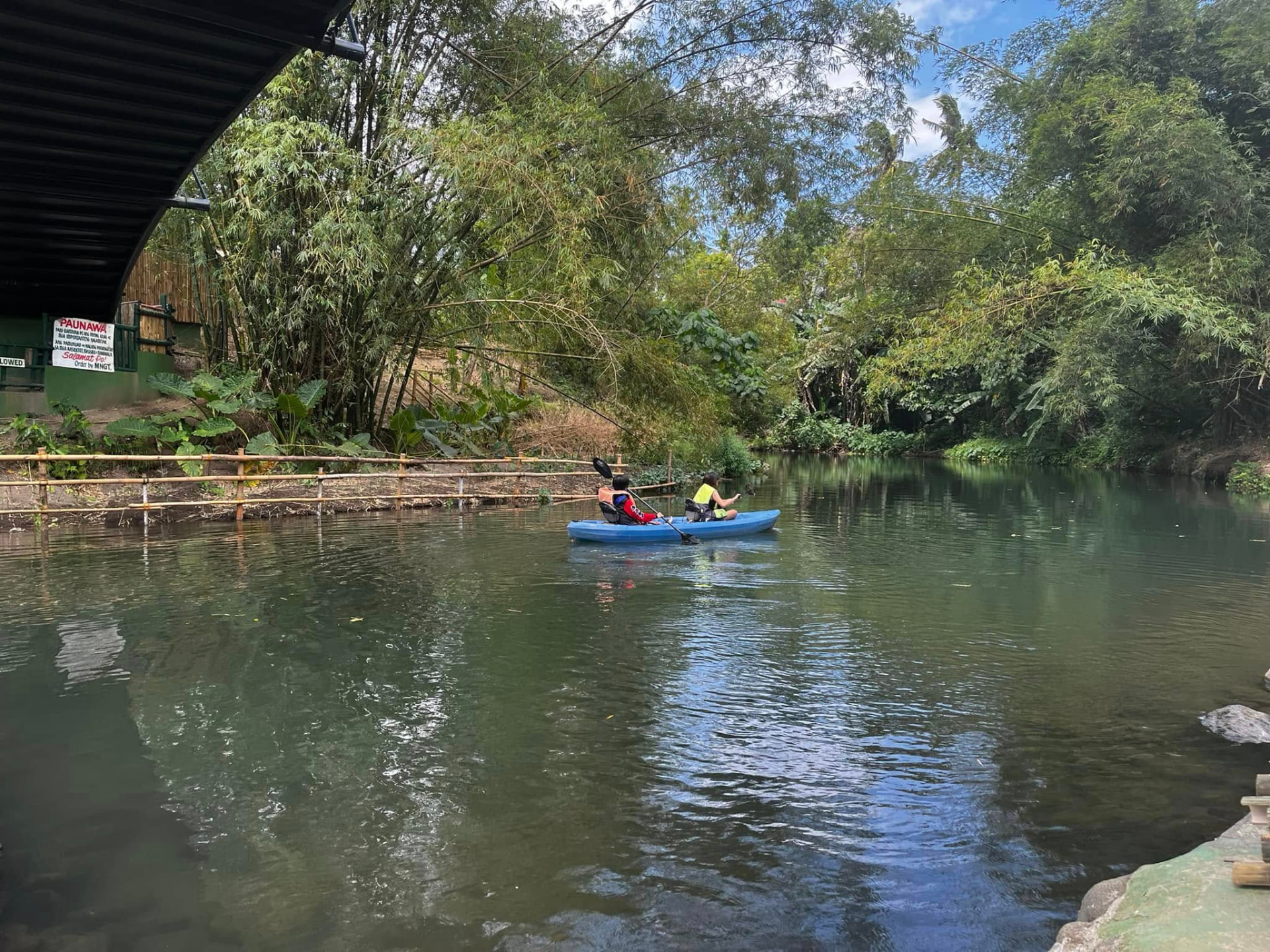 Two people kayaking down a calm river