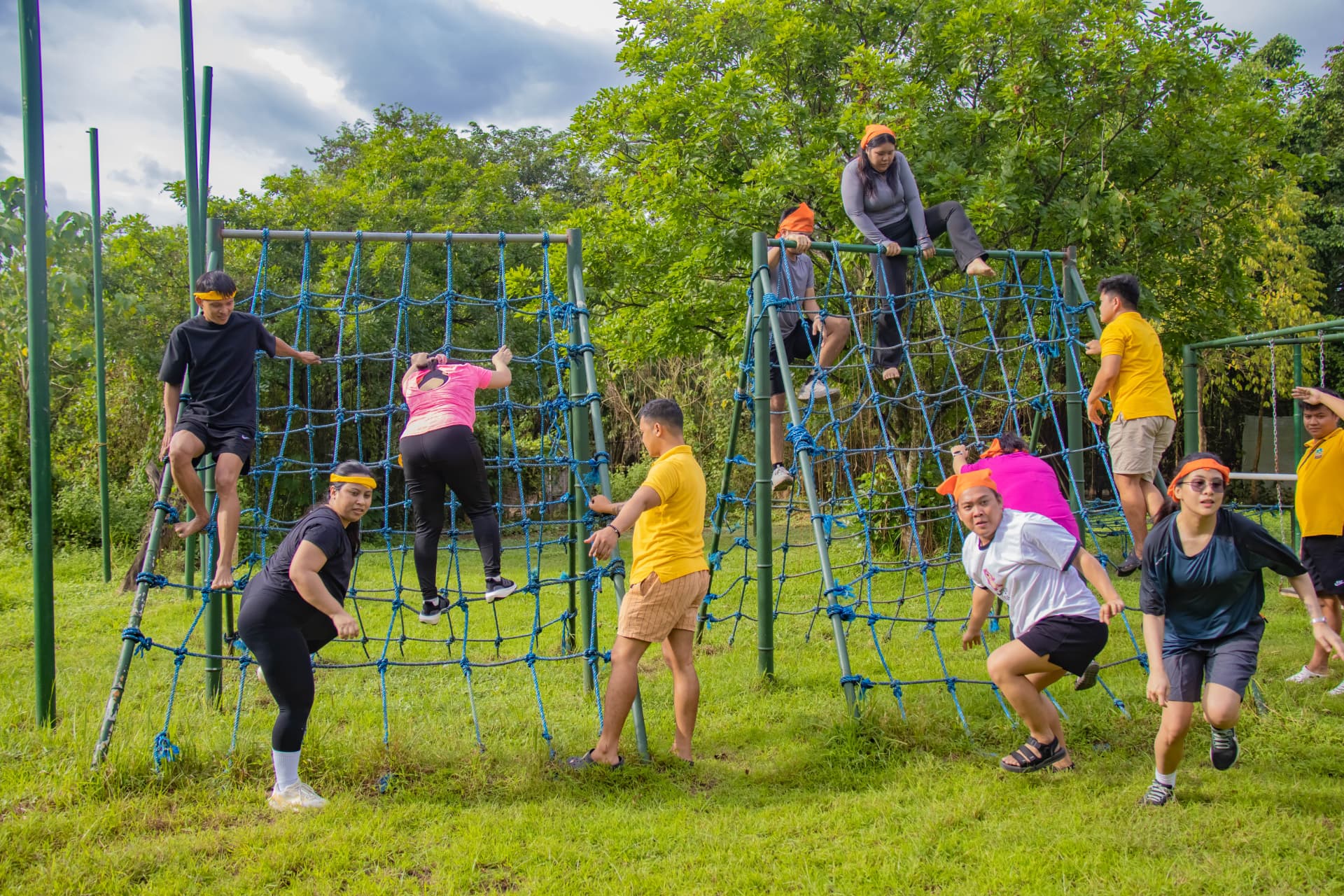 Teammates racing over the cargo net obstacle