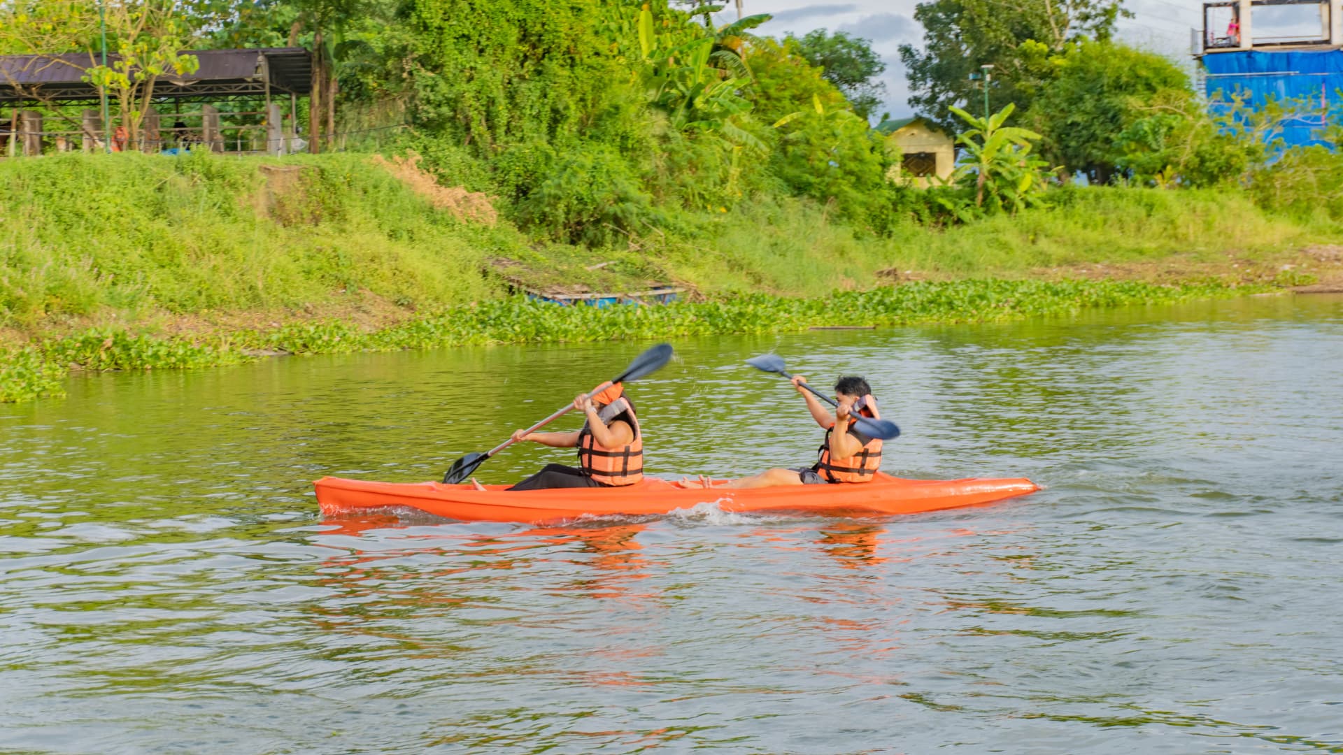 Two teammates paddling a kayak on the lake