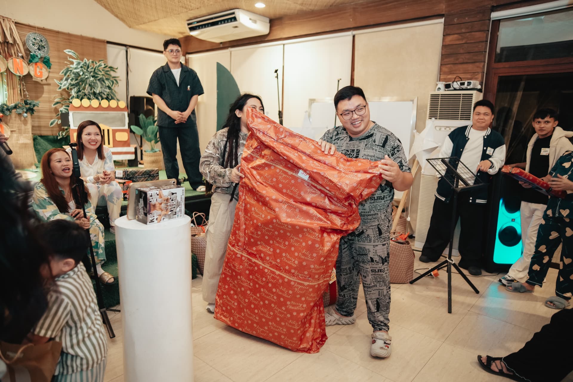 Teammates unwrapping a giant Christmas gift